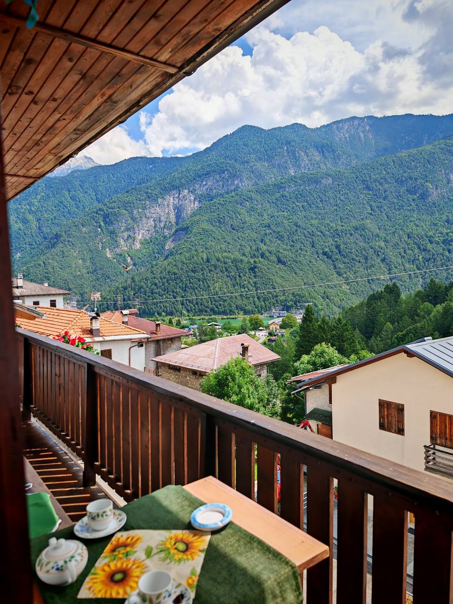 Vista panoramica dal balcone di Rium Dolomiti con tazze da caffè sul tavolo e le Dolomiti sullo sfondo