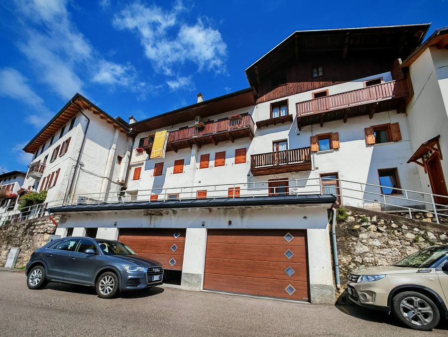 Esterno del palazzo Rium Dolomiti in estate con parcheggio gratuito sul fronte