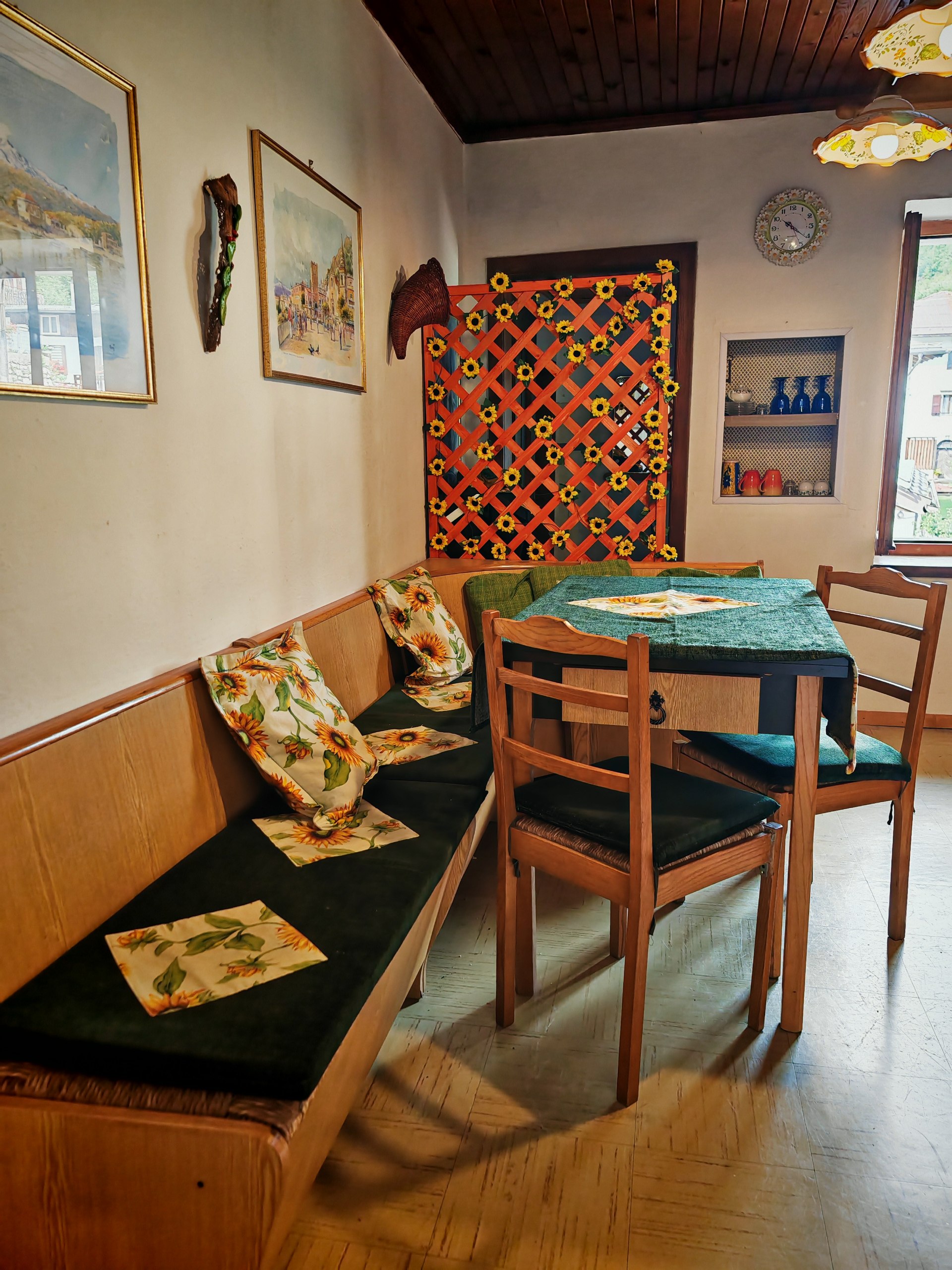 Zona pranzo di Rium Dolomiti con angolo cottura, tavolo in legno e decorazioni vintage